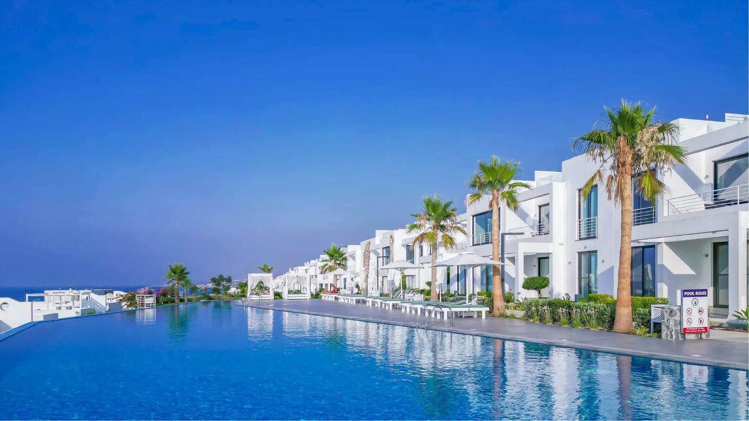 Esentepe sahilinde tamamlanmış Sun Valley Seaside konutları, havuz ve palmiyeler — Sun Valley tanıtım fotoğrafı